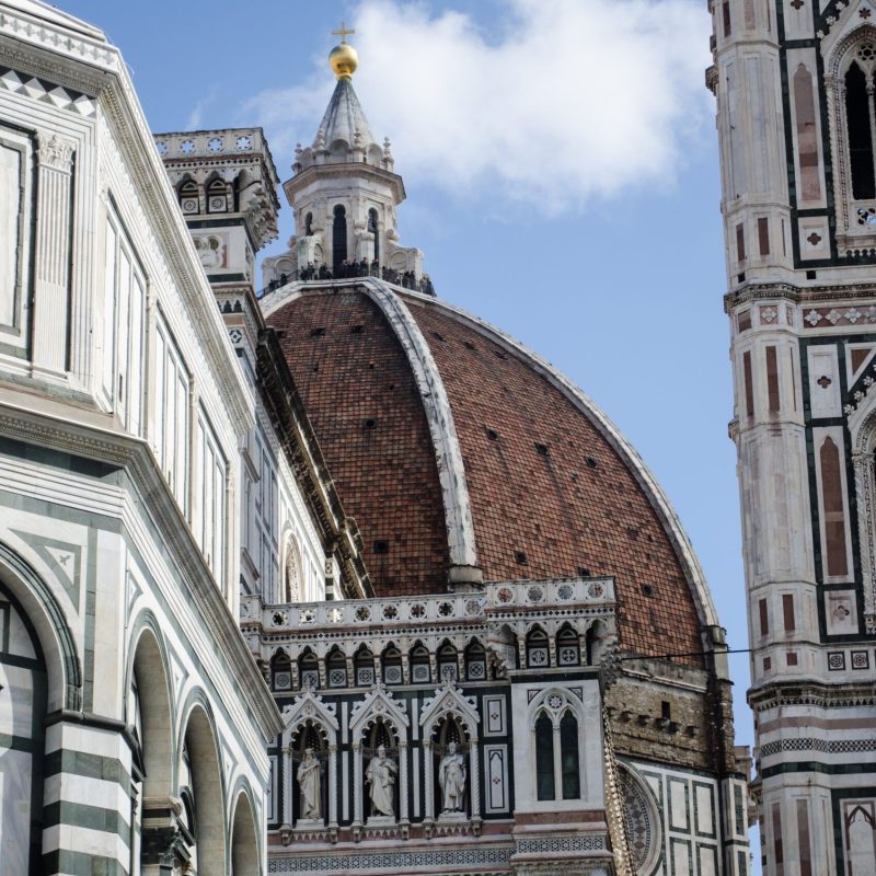 A vertical closeup shot of an ancient  historic dome touching the clear sky